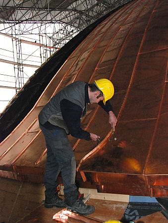 011_17354 - der Klempner schlgt mit dem Hammer die Nhte der Kupferplatten auf dem Dach des Kuppelgebudes an der Elbe.