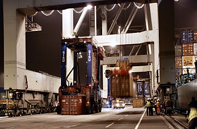 011_15301 - der Portalhubstapelwagen nimmt einen Container auf whrend schon ein weiterer Container vom Containerschiff entladen wurde. 
