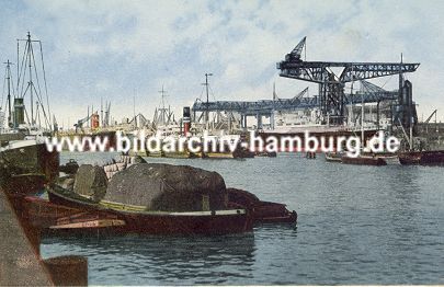11_15746 - historische Aufnahme vom Kuhwerder Hafen; eine beladene Schute lieg am Kai - im Hintergrund Frachtschiffe und eine grosse Krananlage. 