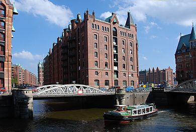 01_15784 - eine Barkasse der Hafenrundfahrt fhrt mit den Hamburg Touristen durch die Kanle der Speicherstadt; Blick zur Kannengiesserortbrcke B - rechts im Hintergrund das Gebude vom Kaispeicher B.