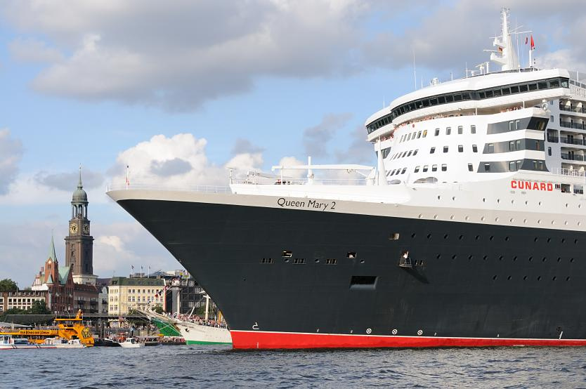 8570 Queen Mary 2 luft aus dem Hamburger Hafen aus - das Passagierschiff fhrt Hhe St. Pauli Landungsbrcken - an Land die Gustav Adolf Kirche und der Michel.