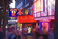 34_41203 Für Hamburg Touristen ist die Reeperbahn der Ausgangspunkt für den Besuch des Hamburger Rotlichtviertels. Die Werbetafeln leuchten im Abendhimmel und laden zum Besuch der Live Show im Moulin Rouge ein. Passanten schlendern über die Sündige Meile, dem Kietz von Hamburg St. Pauli.