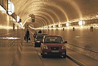 48038 Für Fussgänger und Radfahrer ist die Benutzung kostenfrei; auch die Unterquerung der Elbe ist zeitlich nicht eingeschränkt. Für Kraftfahrzeuge muss eine Nutzungsgebühr bezahlt werden und die Durchfahrt ist nur werktags, Montag bis Freitag von 5:30 bis 20:00 Uhr möglich. Der St. Pauli Elbtunnel wurde 1911 eröffnet und gilt als Meisterleistung der Ingenieurskunst; ca. 4400 Arbeitskräfte arbeiteten fast vier Jahre an den beiden 426m langen Tunnelröhren. Auf zwei Fahrbahnen können Fussgänger und PKW die Elbe in 24m Tiefe unterqueren - Fahrstühle transportieren die Autos und Menschen hinunter.  ©www.bilder- hamburg.de