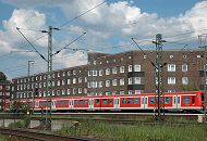 224_0432 Auf den Gleisen Eisenbahnstrecke am Rand der Veddel fhrt ein roter S-Bahnzug zum Hamburger Hauptbahnhof. Nahe der Bahnstrecke liegen die Wohngebude an der Strasse "Am Gleise".