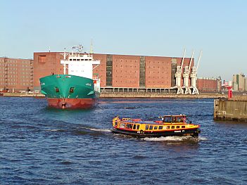 011_14755 eine Barkasse der Hafenrundfahrt und ein Frachtschiff fahren in den Reiherstieg ein; im Hintergrund der Speicher und die drei Laufkrne.