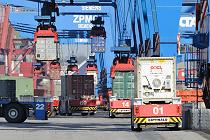 79_6913 Unablässig transportieren die automatischen Transportfahrzeuge die Metallboxen von den Containerbrücken, die am Hafenkai stehen und die Schiffladungen löschen, zu den Lagerblöcken. 