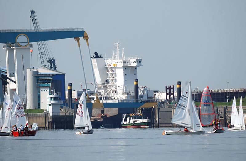 Bilder von der Elbe - Estesperrwerk und Klappbrcke bei Cranz. Segelschiffe auf dem Mhlenberger Loch - Schiffswerft Neuenfelde. 029_4164 Eine Regatte von Optimisten-Jollen findet auf der Elbe beim Mhlenberger Loch statt - eine Elbfhre der HADAG legt gerade vom Anleger Cranz ab. Hinter der Klappbrcke die ber die Mndung der Este und dessen Sperrwerk fhrt ist ein Kran und Schiffsaufbauten der Neuenfelder Sietas-Werft zu erkennen.