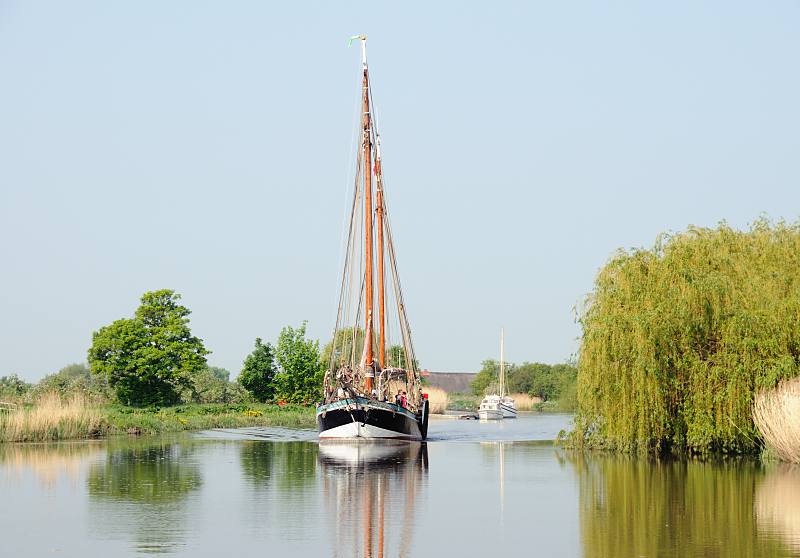 Fotos von dem Fluss Este im Alten Land. Ewer WILHELMINE VON STADE unter Motor in Fahrt flussabwrts auf der Este. 038_7455 Der Ewer WILHELMINE ist ein flachbodiger Frachtsegler, der die Waren aus dem Alten Land auf die Mrkte der umliegenden Stdte brachte. Die Masten sind klappbar, so knnen die Transportschiffe auch niedrige Brcken passieren. Der Ewer WILHELMINE wurde 1912 auf einer Werft an der Pinnau gebaut und von 1981 - 85 aufwndig restauriert.