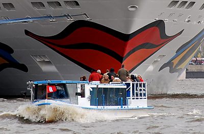 011_15509 - Touristen mustern vom Boot aus die roten Lippen am Bug der AidaDIVA. 