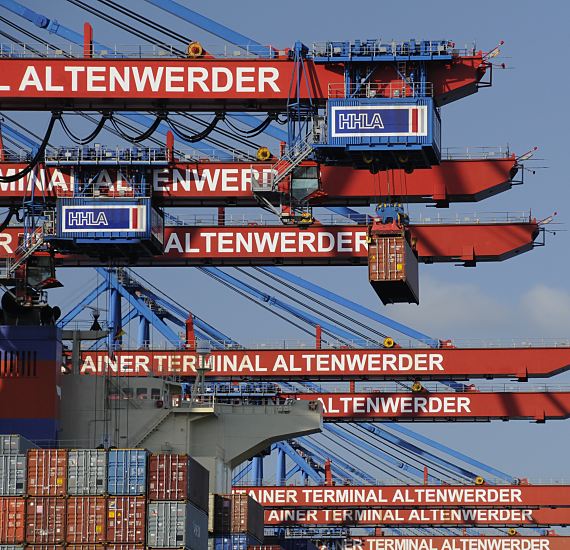 11_21372 Das Container Terminal Altenwerder wird zu 74,9% von der Hamburger Hafen und Logistik AG HHLA und zu 25,1% von der Hapag-Lloyd AG betrieben.  An der Hauptkatze, die den Container transportiert, ist der ist auf blauem Grund der Schriftzug HHLA angebracht, auf den Auslegern der roten Containerbrcken steht "Container Terminal Altenwerder".