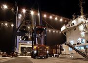 11_21414 Im Hamburger Hafen wird 24 Stunden gearbeitet - ein Container Transporter bringt eine der Stahlkisten zum Athabaskakai des Terminals Burchardkai. An den Containerbrücken befinden sich Lampen, die das Kaigelände beleuchten. ©www.bildarchiv-hamburg.de
