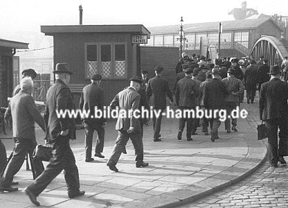 011_17401 - historische Aufnahme ca. 1930 von der Zollgrenze am Baumwall / Kehrwieder. Hafenarbeiter haben Feierabend und gehen am Zollposten vorbei ber die Niederbaumbrcke zur Hochbahnstation Baumwall im Hintergrund.