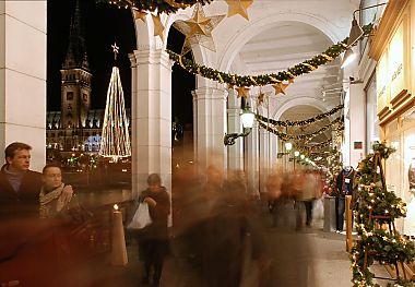 011_15654 - Weihnachtstrubel in den Alster- arkaden; die Geschfte sind mit Tannengirlanden, Weihnachtskugeln und Sternen geschmckt; lks. im Hintergrund ein beleuchteter Weihnachtsbaum und der Rathausturm.