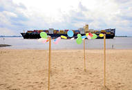 8672 Sandstrand bei Hamburg Blankenese - bunte Luftballons; Reste eines Kinderfestes; auf der Elbe fährt ein Containerfrachter Richtung Hamburger Hafen.