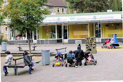 9277 Geschäfte und spielende Kinder auf einem Platz am Alten Teichweg - Bilder aus dem Hamburger Stadtteil Dulsberg.