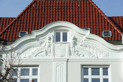 0810 Fassadenschmuck und roten Dachziegeln - Putten mit Jugendstil Ornamente.