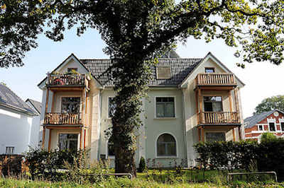 9195 Wohngebäude - Mehrfamilienhaus - mächtige Eiche mit Efeu bewachsen als Strassenbaum.