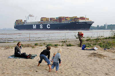 9274 Kinder spielen im Sand an der Elbe - ein Containerfrachter hat den Hamburger Hafen verlassen und fährt elbabwärts Richtung Nordsee.