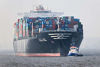 1621 Der Containerfrachter HANJIN SPAIN fährt mit Schlepperhilfe in den Hamburger Hafen ein - hoch beladenes Containerschiff vor Hamburg.