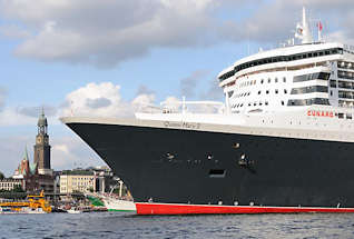 8570 Queen Mary 2 läuft aus dem Hamburger Hafen aus - das Passagierschiff fährt Höhe St. Pauli Landungsbrücken - an Land die Gustav Adolf Kirche und der Michel.
