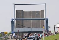 011_7268 Je nach Wasserstand der Lhe + der Elbe, der tideabhngig ist, muss die Klappbrcke ber die Lhe hochgefahren werden, damit die Schiffe die Durchfahrt passieren knnen. In dieser Zeit staut sich der Autoverkehr vor der Klappbrcke; auch Fussgnger und Radfahrer warten auf die Freigabe der Strae.