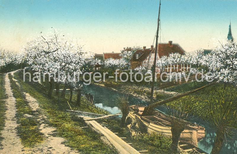 Historisches Bild von der Lhe / Altes Land Blhende Obstbume - ein Ewer liegt am Flussufer. 016_1_214 Fachwerkhuser stehen am Ufer der Lhe - Kirschbume blhen; ein Ewer liegt vertut zwischen Kopfweiden im Schilf, die Seitenschwerter sind hochgezogen - Planken fhren als Weg zum Lastschiff. Fast jeder Obsthof transportierte seine Obsterne mit dem Lastsegler ber Elbe zumeist auf den Markt nach Hamburg.