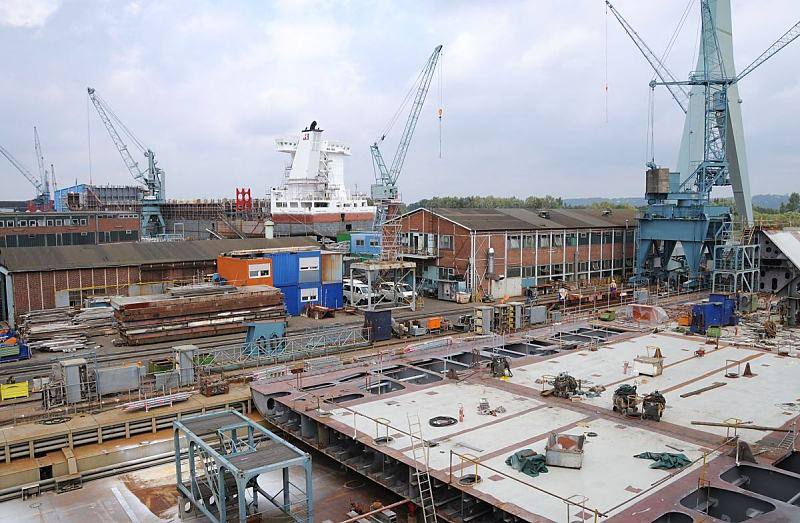 Hamburger Bilder - Schiffwerft Sietas KG, Hamburg  Neuenfelde. Werftgelnde der Traditionswerft am Ufer der Este. 032_5191 Blick ber die Sietas-Werft in Hamburg Neuenfelde. Im Vordergrund liegt ein halbfertiges Schiffssegment, whrend hinter den Arbeitshallen die frisch gestrichenen Aufbauten ein Schiffsneubaus zu erkennen sind. Die traditionsreiche Sietas Schiffswerft hat ihren Ursprung schon 1635 - an der Este gab es frher viele Schiffswerften, auf denen u.a die Lastsegler fr den Gtertransport gebaut wurden.