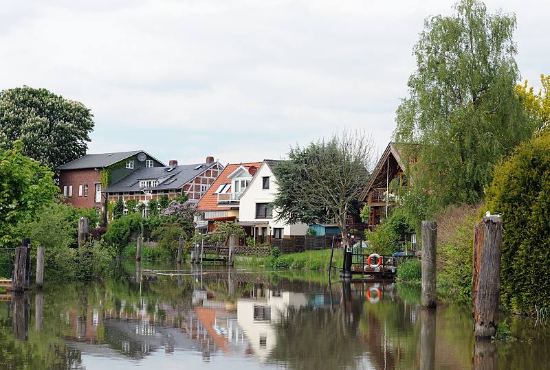 Bilder aus dem Alten Land - Wasserstrasse Este. Wohnhuser am Ufer des Flusses - Bootsanleger und Holzdalben.  052_4318 Die Grten und Wiesen der Wohnhuser liegen direkt am Ufer der Este. Fast jedes Haus hat einen Bootsanleger fr ein kleines Motorboot oder Segelschiff, um damit auf der Elbe zu segeln. Alte Holzdalben sind Zeugnis des frheren Gterverkehrs mit Lastseglern auf dem Fluss. Neben Erzeugnisse der Mhlen und Ziegeleien wurde auch die Obsternte auf dem Wasserwege transportiert.