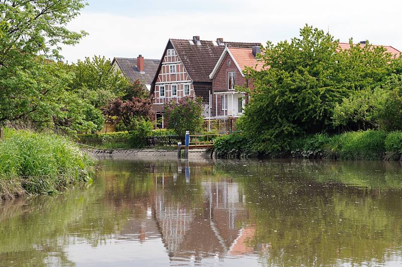 Bilder aus dem Alten Land - Fluss im Alten Land, Wasserweg Este. Wohnhuser am Fluss- Ufer; Bootsanleger.  053_7429 Die Wohnhuser liegen direkt am Ufer der Este - fast jedes der Einzelhuser hat einen eigenen Bootsanleger fr ein Sportboot. Ein Gtertransport auf dem Altlnder Wasserweg, wie er frher z.B. mit Ewern  vorgenommen wurde, finde nicht mehr statt - die Este ist ein Sportbootrevier geworden.