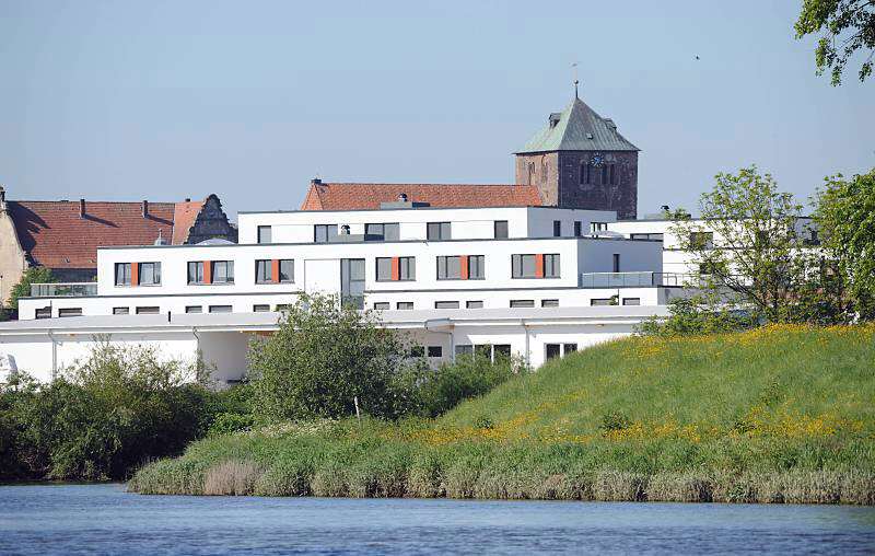 Moderne Neubauten - historische gotische St. Wilhadi Kirche, Stade. Aufnahmen der Sehenswrdigkeiten aus der Hamburger Metropolregion. 074_4793 Blick ber die Schwinge nach Stadt. Am Ufer des niederschsischen Flusse weisse Neubauten, dahinter die historische St. Wilhadi Kirche. Die gotische Kirche  wurde nach dem Bischof Willehard benannt, der als Missionar in Friesland und Sachsen aktiv war und heilig gesprochen wurde.