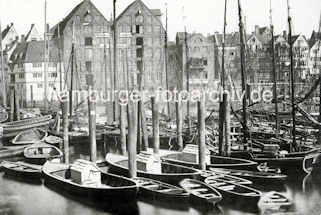 X002154 Alte Fotografie vom Hamburger Binnenhafen bei der Straße Kajen; dicht zusammengedrängt liegen die Boote an den Dalben. Im Hintergrund Lagerhäuser und Wohngebäude am Hafenrand.