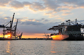 0848 Das 2010 fertiggestellte Containerschiff CMA CGM CALISTO hat eine Länge von 364m und eine Breite von 45,6m. Der Containerriese kann 11 356 TEU Standartdcontainer transportieren. Sonnenuntergang im Hafen Hamburgs, die CMA CGM CALISTO liegt am Burchardkai des HHLA Containerterminals unter den Containerbrücken.